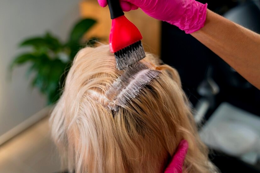 Femme blonde teint ses cheveux avec la coloration végétale