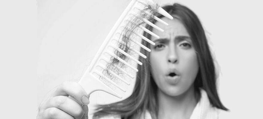 Femme montrant la chute de ses cheveux avec un peigne