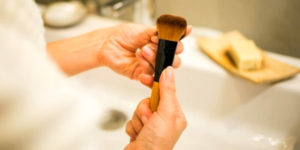 Femme nettoyant un pinceau de maquillage