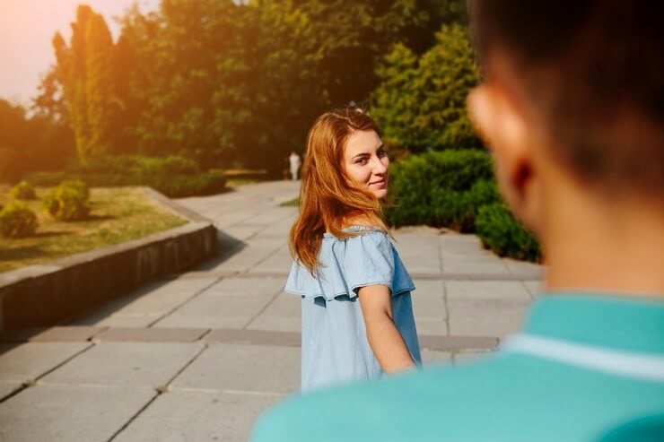 Belle femme regarde derrière un homme timide